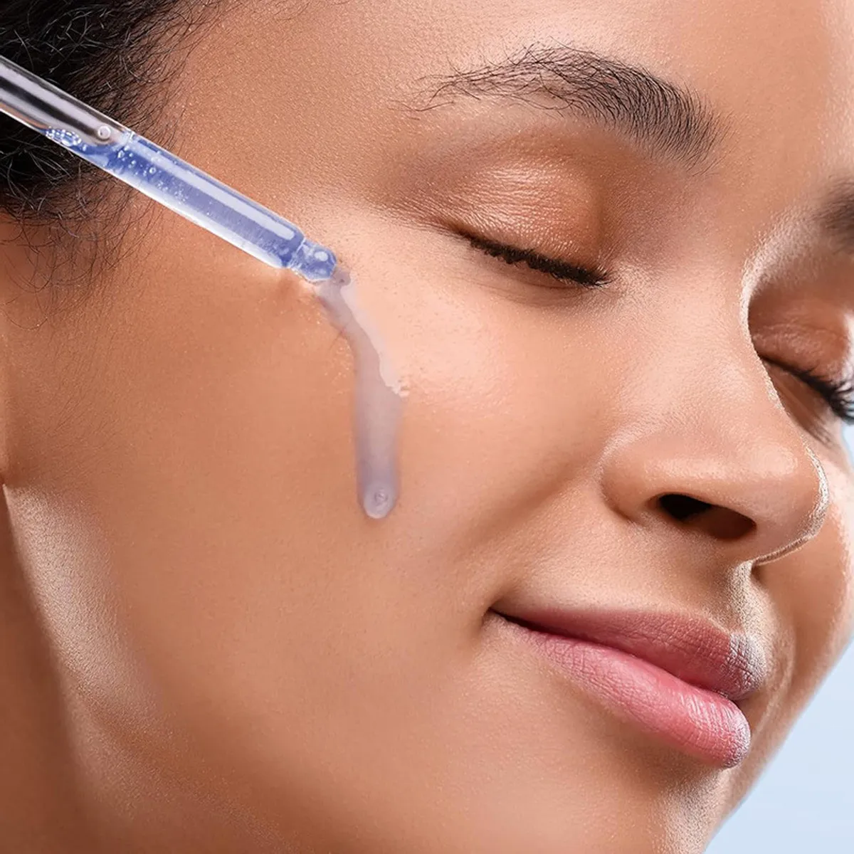 Dropper of Cellovate serum applied to glowing skin
