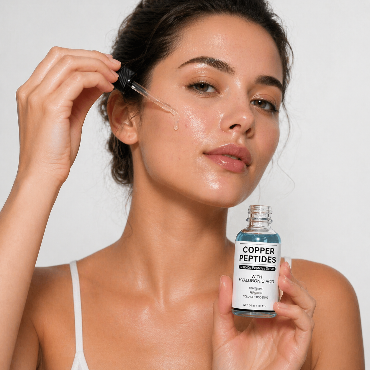 Woman with luminous skin holding Cellovate Copper Peptides serum